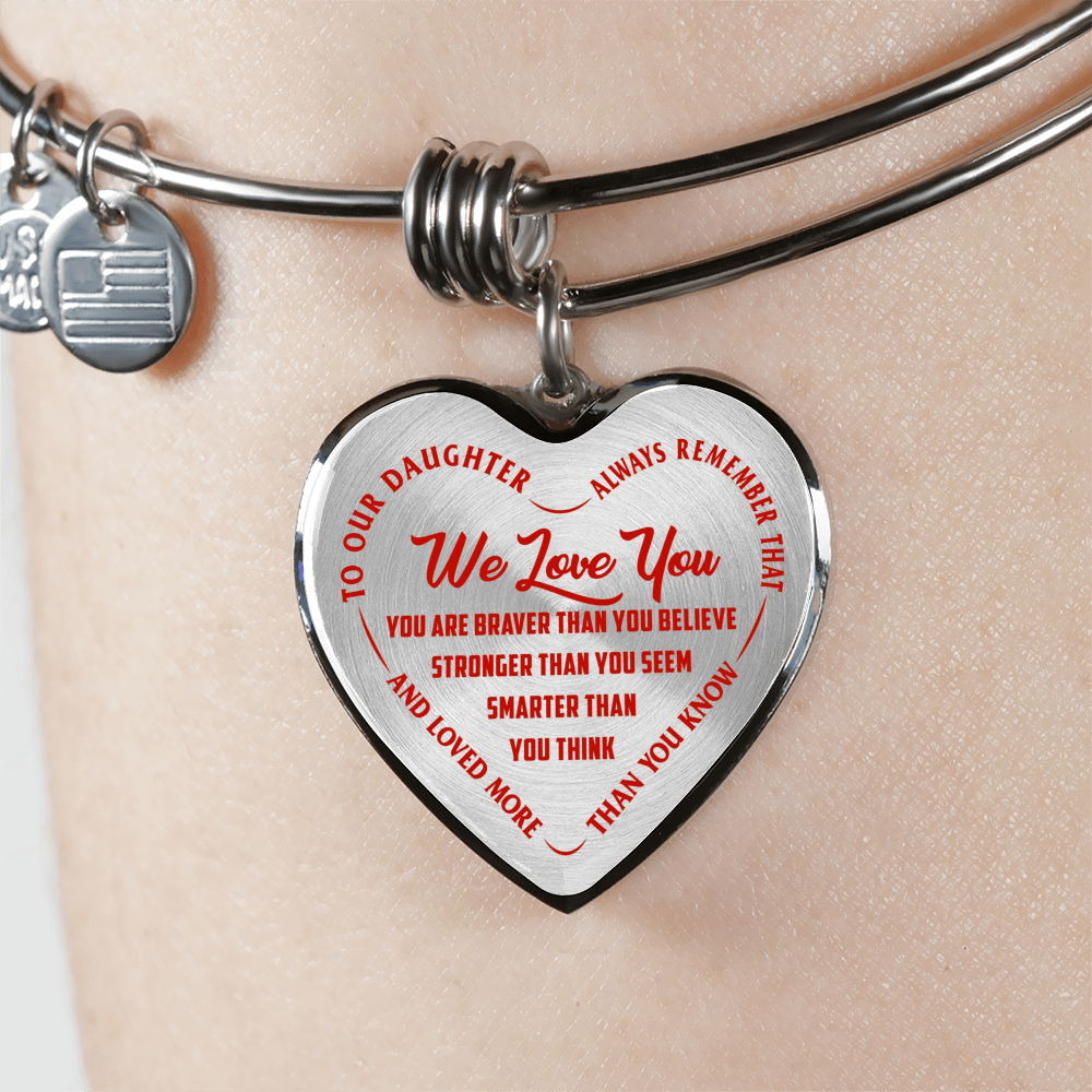 TO OUR DAUGHTER, WE LOVE YOU - SILVER OR GOLD FINISHED HEART SHAPED BANGLE BRACELET (RED ON TRANSPARENT)