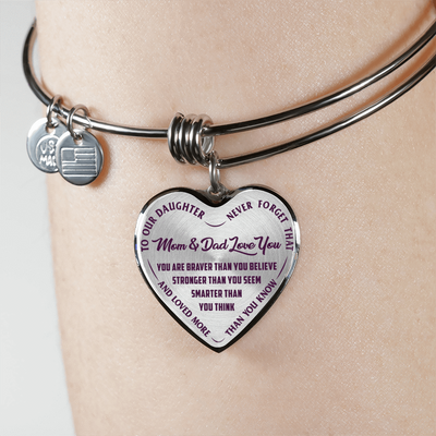 TO OUR DAUGHTER, YOU ARE BRAVER, MOM & DAD LOVE YOU - GOLD AND SILVER FINISHED HEART SHAPED BANGLE BRACELET (PURPLE TEXT ON TRANSPARENT)