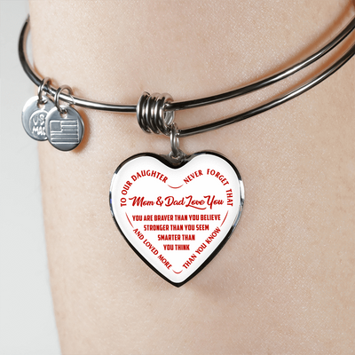 TO OUR DAUGHTER, YOU ARE BRAVER, MOM & DAD LOVE YOU - GOLD AND SILVER FINISHED HEART SHAPED BANGLE BRACELET (RED TEXT ON WHITE)