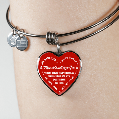 TO OUR DAUGHTER, YOU ARE BRAVER, MOM & DAD LOVE YOU - GOLD AND SILVER FINISHED HEART SHAPED BANGLE BRACELET (WHITE TEXT ON RED)