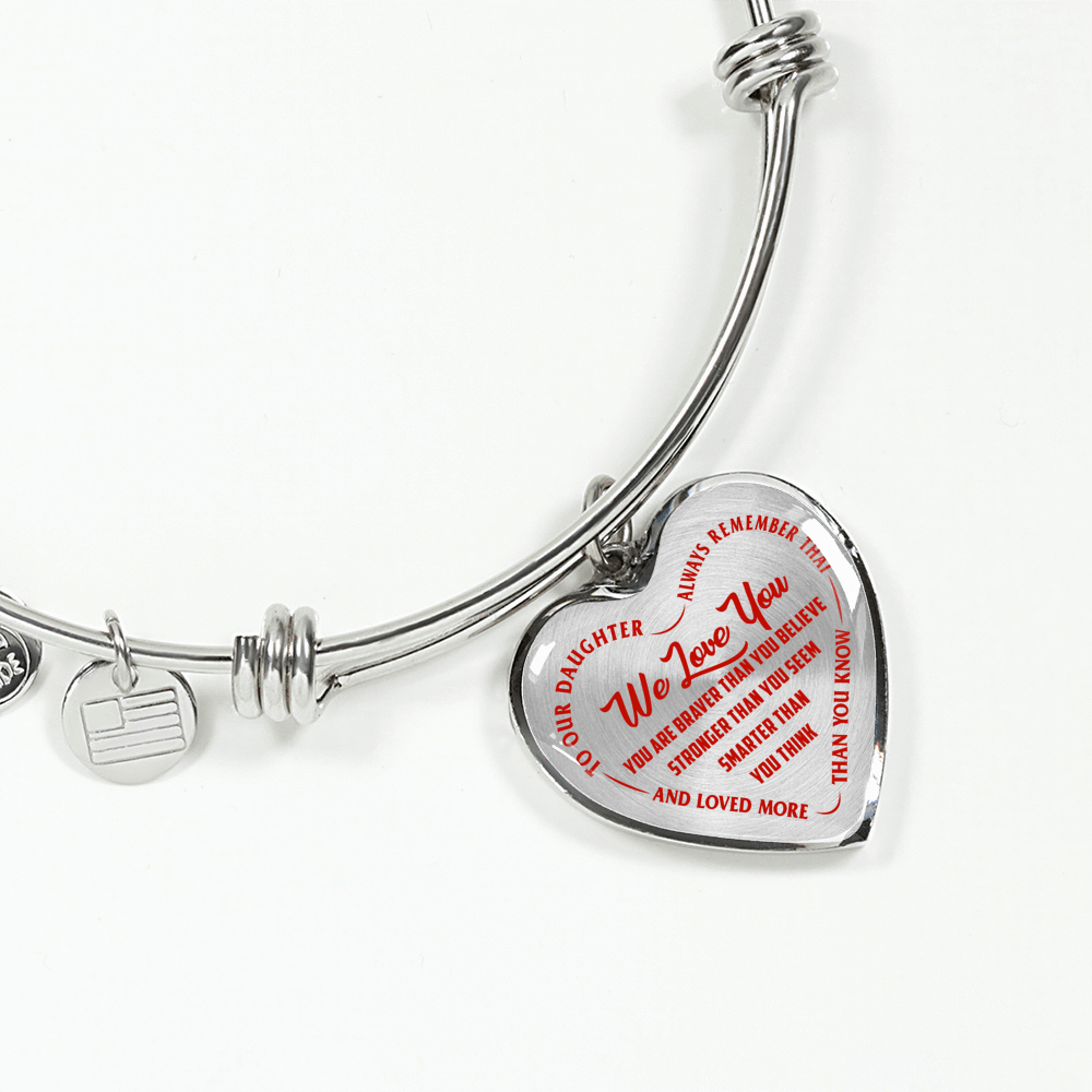 TO OUR DAUGHTER, WE LOVE YOU - SILVER OR GOLD FINISHED HEART SHAPED BANGLE BRACELET (RED ON TRANSPARENT)