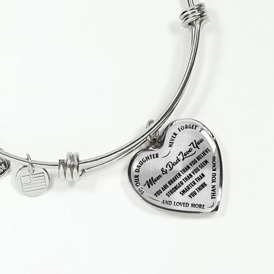 TO OUR DAUGHTER, YOU ARE BRAVER, MOM & DAD LOVE YOU - GOLD AND SILVER FINISHED HEART SHAPED BANGLE BRACELET (BLACK TEXT ON TRANSPARENT)