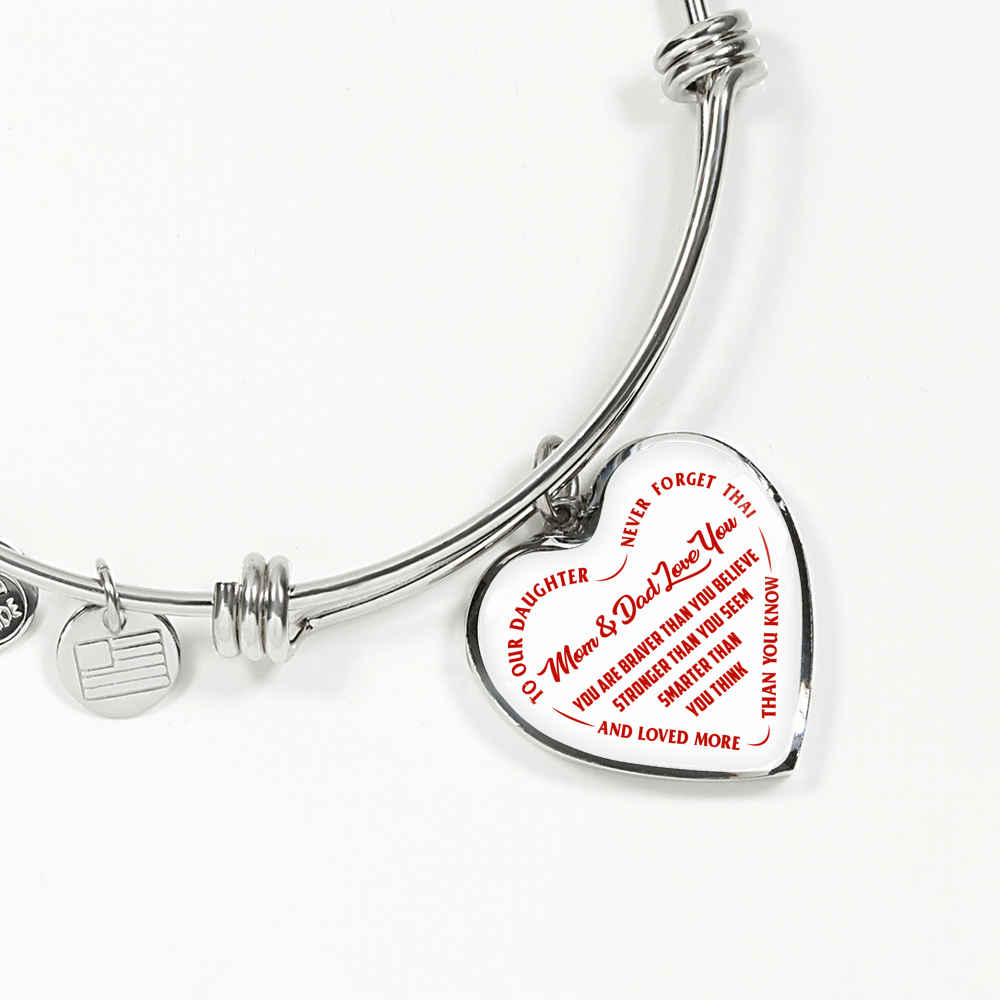 TO OUR DAUGHTER, YOU ARE BRAVER, MOM & DAD LOVE YOU - GOLD AND SILVER FINISHED HEART SHAPED BANGLE BRACELET (RED TEXT ON WHITE)