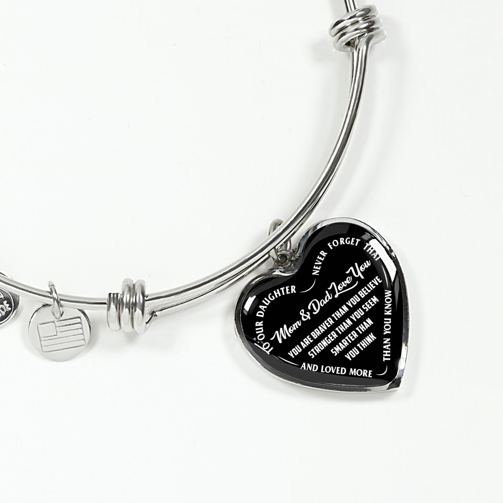 TO OUR DAUGHTER, YOU ARE BRAVER, MOM & DAD LOVE YOU - GOLD AND SILVER FINISHED HEART SHAPED BANGLE BRACELET (WHITE TEXT ON BLACK)