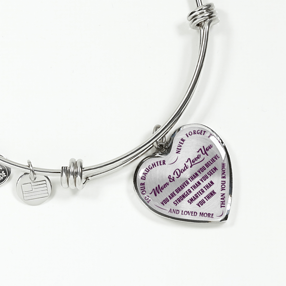TO OUR DAUGHTER, YOU ARE BRAVER, MOM & DAD LOVE YOU - GOLD AND SILVER FINISHED HEART SHAPED BANGLE BRACELET (PURPLE TEXT ON TRANSPARENT)