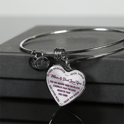 TO OUR DAUGHTER, YOU ARE BRAVER, MOM & DAD LOVE YOU - GOLD AND SILVER FINISHED HEART SHAPED BANGLE BRACELET (PURPLE TEXT ON TRANSPARENT)