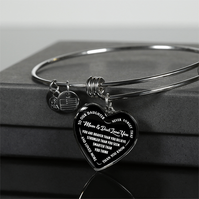 TO OUR DAUGHTER, YOU ARE BRAVER, MOM & DAD LOVE YOU - GOLD AND SILVER FINISHED HEART SHAPED BANGLE BRACELET (WHITE TEXT ON BLACK)