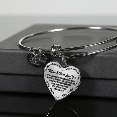 TO OUR DAUGHTER, MOM & DAD LOVE YOU, NEVER FORGET THAT - GOLD AND SILVER FINISHED HEART SHAPED BANGLE BRACELET (BLACK TEXT ON TRANSPARENT)