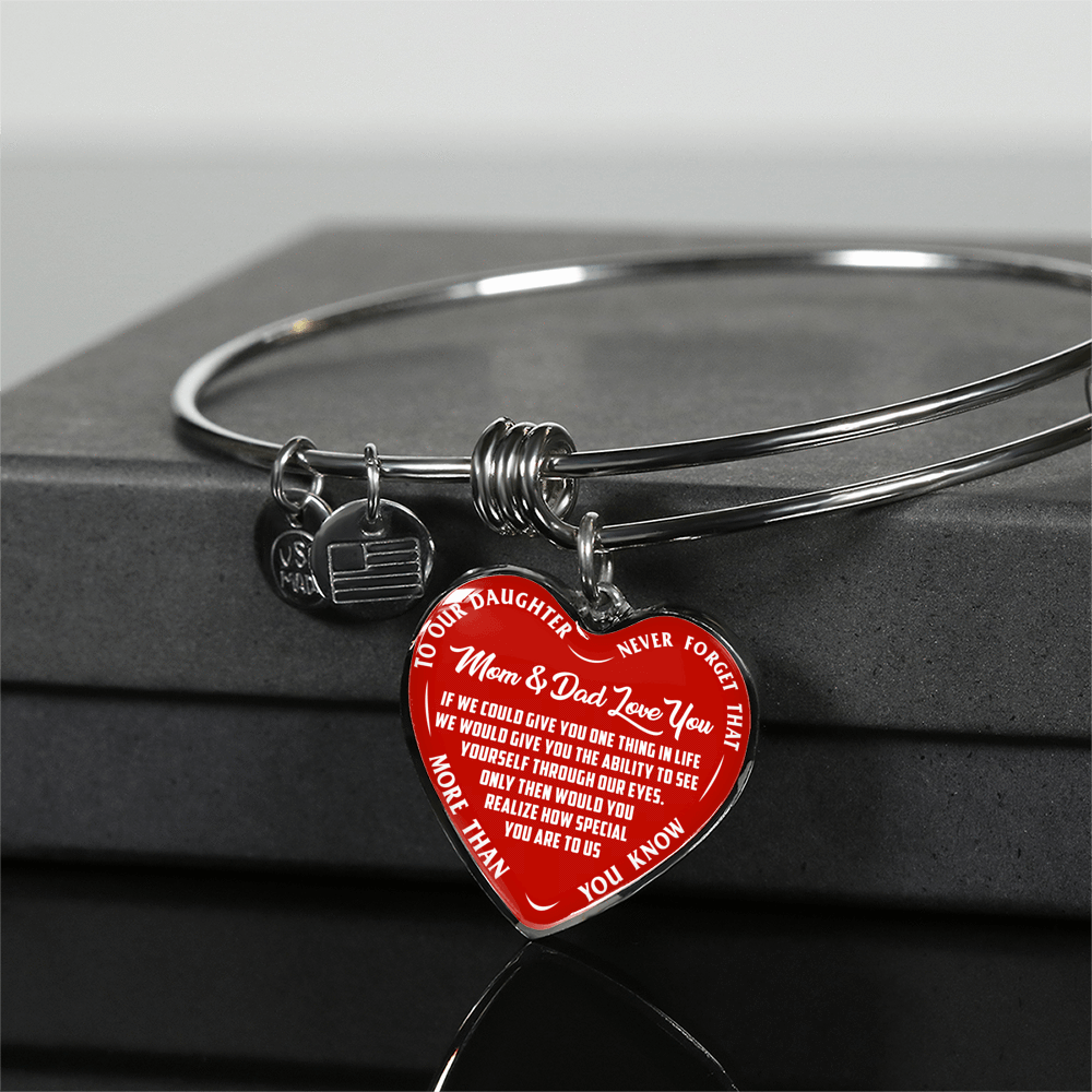 TO OUR DAUGHTER, MOM & DAD LOVE YOU, NEVER FORGET THAT - GOLD AND SILVER FINISHED HEART SHAPED BANGLE BRACELET (WHITE TEXT ON RED)