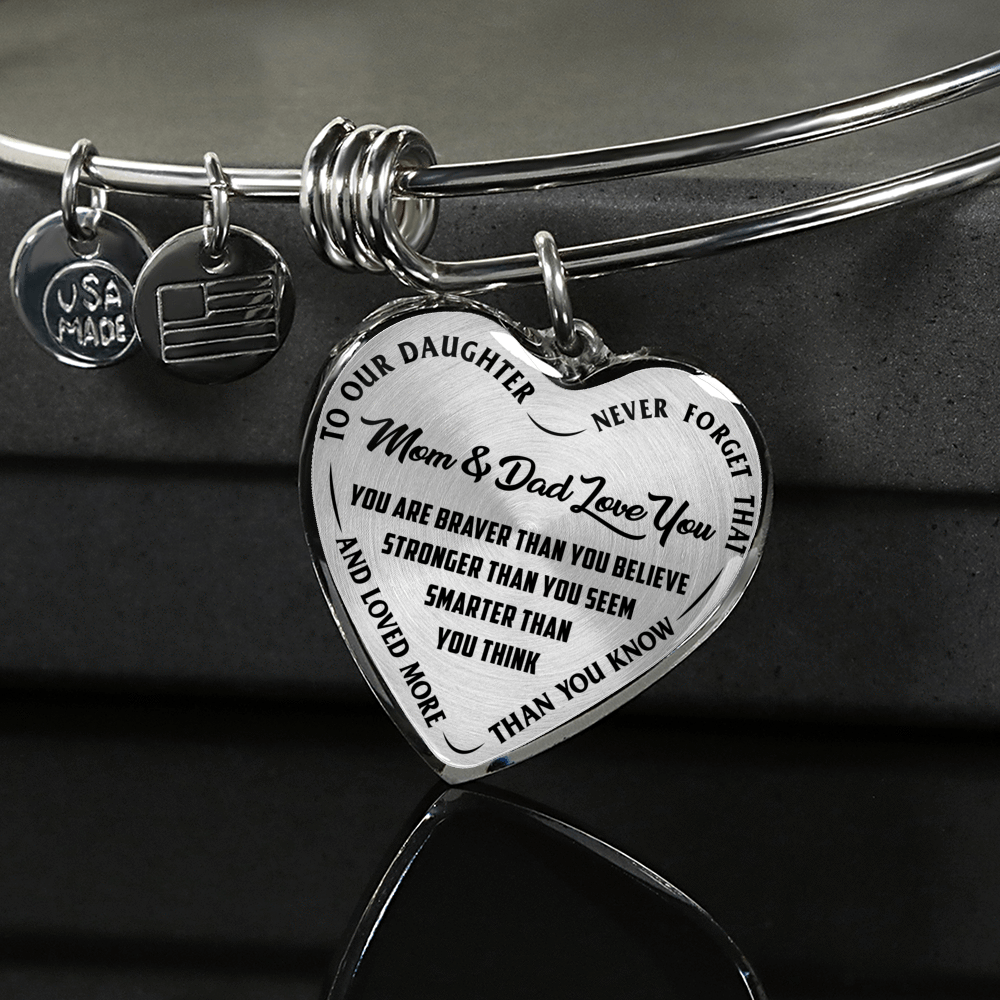 TO OUR DAUGHTER, YOU ARE BRAVER, MOM & DAD LOVE YOU - GOLD AND SILVER FINISHED HEART SHAPED BANGLE BRACELET (BLACK TEXT ON TRANSPARENT)