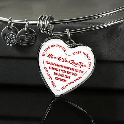 TO OUR DAUGHTER, YOU ARE BRAVER, MOM & DAD LOVE YOU - GOLD AND SILVER FINISHED HEART SHAPED BANGLE BRACELET (RED TEXT ON WHITE)