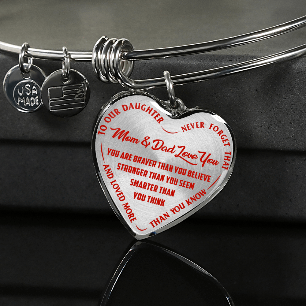 TO OUR DAUGHTER, YOU ARE BRAVER, MOM & DAD LOVE YOU - GOLD AND SILVER FINISHED HEART SHAPED BANGLE BRACELET (RED TEXT ON TRANSPARENT)