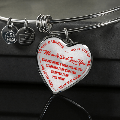 TO OUR DAUGHTER, YOU ARE BRAVER, MOM & DAD LOVE YOU - GOLD AND SILVER FINISHED HEART SHAPED BANGLE BRACELET (RED TEXT ON TRANSPARENT)