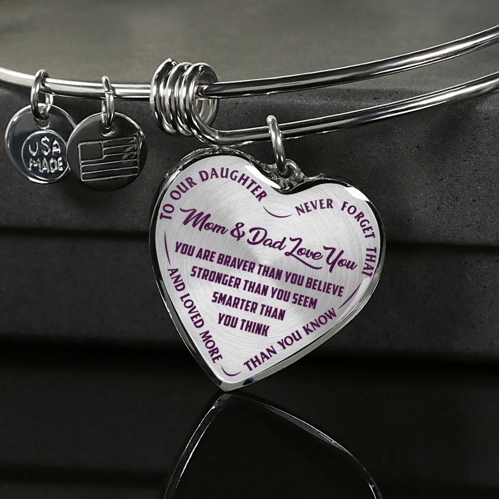 TO OUR DAUGHTER, YOU ARE BRAVER, MOM & DAD LOVE YOU - GOLD AND SILVER FINISHED HEART SHAPED BANGLE BRACELET (PURPLE TEXT ON TRANSPARENT)