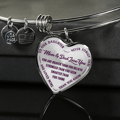 TO OUR DAUGHTER, YOU ARE BRAVER, MOM & DAD LOVE YOU - GOLD AND SILVER FINISHED HEART SHAPED BANGLE BRACELET (PURPLE TEXT ON TRANSPARENT)