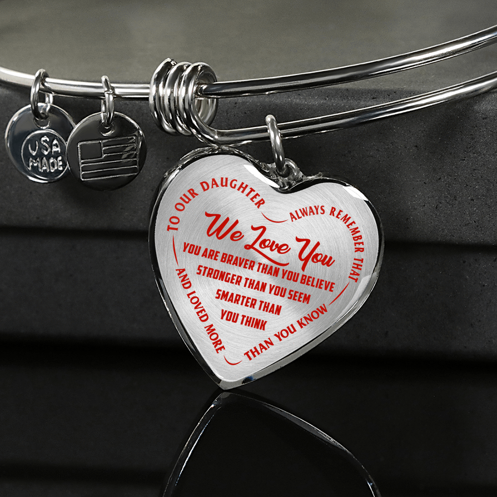 TO OUR DAUGHTER, WE LOVE YOU - SILVER OR GOLD FINISHED HEART SHAPED BANGLE BRACELET (RED ON TRANSPARENT)